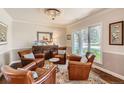 Cozy sitting area with four leather chairs, hardwood floors, and a decorative chandelier at 13 Club Ln, Littleton, CO 80123