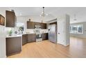 Spacious kitchen featuring stainless steel appliances, sleek countertops, dark wood cabinets, and natural light at 5051 Yates Cir, Broomfield, CO 80020