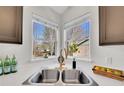 Modern kitchen sink with stainless steel basin and views of the outside through corner windows at 5051 Yates Cir, Broomfield, CO 80020