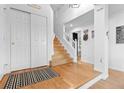 Bright entryway featuring hardwood floors, a staircase, coat closet, and an open floor plan at 8635 Cresthill Ln, Highlands Ranch, CO 80130