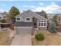 Beautiful two-story home with gray siding, stone accents, landscaped front yard, and a two-car garage at 8635 Cresthill Ln, Highlands Ranch, CO 80130