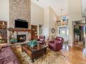 Comfortable living room with stone fireplace, hardwood floors, and vaulted ceiling at 1660 Prominence Cir, Elizabeth, CO 80107