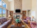Comfortable living room with stone fireplace, built-in shelves and vaulted ceiling at 1660 Prominence Cir, Elizabeth, CO 80107