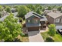 An aerial view showcasing a well-maintained home with a large yard and mature trees at 9698 Queenscliffe Dr, Highlands Ranch, CO 80130
