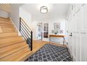 Bright foyer with hardwood floors, elegant staircase, and stylish decor at 7082 W Morraine Dr, Littleton, CO 80128