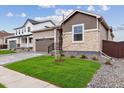 Charming single-Gathering home showcasing stone accents, a two-car garage, and a well-manicured lawn at 19110 E 96Th Pl, Commerce City, CO 80022