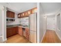 A kitchen with wooden cabinets, stainless steel appliances, and hardwood floors at 1020 15Th St # 18I, Denver, CO 80202