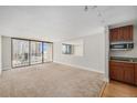 A living room with a view of the city, carpeted floors, and a combined kitchen at 1020 15Th St # 18I, Denver, CO 80202
