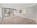 An empty living room featuring carpet, a large window, and a view of the city at 1020 15Th St # 18I, Denver, CO 80202