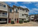 Three-story townhouse with brick accents, red doors, and attached garages, offering convenient living at 4947 Noble Park Pl, Boulder, CO 80301