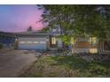 Charming single-story home featuring a brick facade, two car garage, and xeriscaped front yard at twilight at 540 Ithaca Dr, Boulder, CO 80305