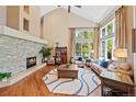 Bright living room boasting a high ceiling, fireplace, hardwood floors, and lots of natural light from large windows at 4 White Fir Ct, Littleton, CO 80127