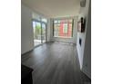 Bright living room featuring hardwood floors, large windows, and sliding door to balcony at 336 E 1St Ave # 200, Denver, CO 80203