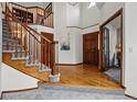 Welcoming foyer with hardwood floors, a staircase with wood railings, and a view to the upper level at 8427 Pierson Ct, Arvada, CO 80005