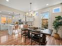 Bright dining area featuring a wooden table, elegant chandelier, and easy access to the modern kitchen and outdoor area at 2801 W 23Rd Ave, Denver, CO 80211