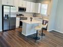 Bright kitchen features white cabinets, an island with seating, and stainless steel appliances at 1353 Reynolds St # 5A, Fort Lupton, CO 80621