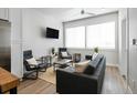 Open living area with grey sectional, two armchairs, and a wood coffee table at 1208 Quitman St # 303, Denver, CO 80204