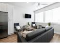 Bright living room with grey sofas and chairs, coffee table, and ceiling fan at 1208 Quitman St # 303, Denver, CO 80204