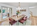 Elegant dining room with a long wooden table, red upholstered chairs, and modern lighting fixture at 10016 Teton Ct, Lone Tree, CO 80124