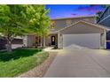 Charming two-story home with a well-manicured lawn, mature tree, and an attached two-car garage at 10016 Teton Ct, Lone Tree, CO 80124