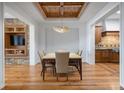 Elegant dining room with hardwood floors, designer lighting, and a coffered wood ceiling at 4364 Chateau Ridge Ln, Castle Rock, CO 80108