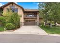 Charming two-story house featuring an attached garage, stone accents, balcony, and a well-manicured lawn at 4364 Chateau Ridge Ln, Castle Rock, CO 80108