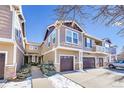 Two-story townhome features attached garages, stylish siding, and snow-covered landscaping at 17359 Waterhouse Cir # C, Parker, CO 80134