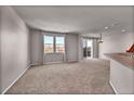 The open-concept living room has large windows, sliding glass door, and neutral paint tones at 17359 Waterhouse Cir # C, Parker, CO 80134