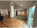 Open concept living room featuring hardwood floors, fireplace, and view into kitchen at 6921 S Bryant St, Littleton, CO 80120