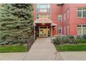 Inviting building entrance with well-maintained landscaping and red brick facade at 300 Hudson St # 202, Denver, CO 80220