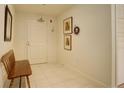 Bright hallway with tiled floors, bench, and decorative wall art at 300 Hudson St # 202, Denver, CO 80220