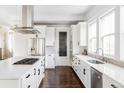 White kitchen with stainless steel appliances and an island at 6003 Chester Way, Denver, CO 80238