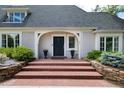 Charming home entrance with brick steps, stone retaining wall, and beautiful landscaping at 1512 Cottonwood Ln, Greenwood Village, CO 80121
