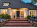 Elegant home entrance featuring a brick walkway, well-manicured shrubs, and a classic black front door at 1512 Cottonwood Ln, Greenwood Village, CO 80121