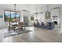 Bright, open kitchen with a large island, modern appliances, and a dining area with large windows at 3343 S Newcombe St, Lakewood, CO 80227