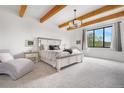 Serene main bedroom featuring exposed wood beams, large windows, and stylish furnishings at 3343 S Newcombe St, Lakewood, CO 80227