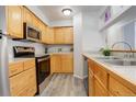Galley kitchen with light wood cabinets and stainless steel appliances at 14602 E 2Nd Ave # 100C, Aurora, CO 80011