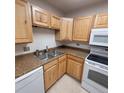 Kitchen boasting light wood cabinets and speckled countertops, equipped with essential appliances at 755 S Clinton St # 1B, Denver, CO 80247