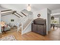 Bright entryway featuring hardwood floors, a staircase, and a view into the living and dining areas at 10385 E Ida Ave, Greenwood Village, CO 80111