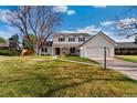 Traditional two-story home with white siding, black shutters, and a spacious front yard at 10385 E Ida Ave, Greenwood Village, CO 80111