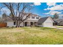 Beautifully landscaped two-story home with a spacious lawn, inviting entrance, and an attached garage at 10385 E Ida Ave, Greenwood Village, CO 80111