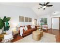 Bright living room with vaulted ceilings, hardwood floors, comfortable leather seating, and a large window at 13504 Pecos St, Westminster, CO 80234