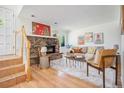 Cozy living room with stone fireplace, staircase, and neutral decor, creating a warm and inviting atmosphere at 19 Benthaven Pl, Boulder, CO 80305