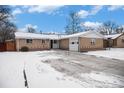 Ranch home with attached garage and snowy yard at 460 Iola St, Aurora, CO 80010