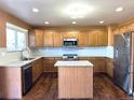 Modern kitchen boasts stainless steel appliances, granite countertops, and a functional center island at 9377 Longstone Dr, Parker, CO 80134