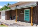 Close up of a brick home featuring a teal-colored front door with modern design details at 8333 Depew Way, Arvada, CO 80003