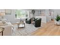 Bright living room featuring a large window, modern furnishings, and beautiful hardwood floors at 8333 Depew Way, Arvada, CO 80003
