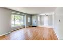 Bright living room with hardwood floors, large window, and fresh paint throughout at 1170 Kingston St, Aurora, CO 80010