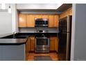 Well-lit kitchen features stainless steel appliances, light wood cabinets, and dark granite countertops at 8400 S Upham Way # E4, Littleton, CO 80128