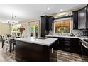 Open-concept kitchen with dark wood cabinets, stainless steel appliances, and an island with a sink at 139 N Prairie Falcon Pkwy, Brighton, CO 80601